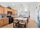 A kitchen features wooden cabinets, granite countertops, a center island with stools, and stainless steel appliances at 16165 W Vale Dr, Goodyear, AZ 85395