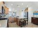 This bright kitchen features warm wood cabinets, granite counters, a center island, and stainless steel appliances at 16165 W Vale Dr, Goodyear, AZ 85395