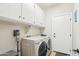 A tidy laundry room features modern washer and dryer, ample storage cabinets, and a convenient layout at 16165 W Vale Dr, Goodyear, AZ 85395