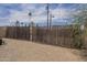 A view of the backyard with a tall wooden fence and gravel ground at 1637 W University Dr, Mesa, AZ 85201