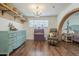 Bedroom with chandelier, hardwood floors, vintage dresser, and brick archway leading to bed at 1637 W University Dr, Mesa, AZ 85201