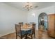 Bright dining room with wood table, seating for four, chandelier and arched entry at 1637 W University Dr, Mesa, AZ 85201