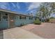 Exterior view of a charming blue home with a well-maintained yard and tiled walkway, enhancing curb appeal at 1637 W University Dr, Mesa, AZ 85201