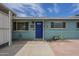 Exterior view of a blue home featuring a blue front door, tile landscaping, and a manicured yard for inviting curb appeal at 1637 W University Dr, Mesa, AZ 85201