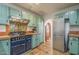 Updated kitchen showcasing turquoise cabinetry, tile counters, and vintage-style range at 1637 W University Dr, Mesa, AZ 85201