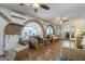 Spacious living room with tiled floors, brick arches, wicker furniture, and abundant natural light at 1637 W University Dr, Mesa, AZ 85201