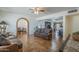 Bright, open living room featuring ceiling fans, tile flooring, and a brick archway leading to the dining area at 1637 W University Dr, Mesa, AZ 85201