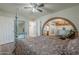 Bedroom with four-poster bed, brick arch, hardwood floors, ceiling fan, and ensuite access at 1637 W University Dr, Mesa, AZ 85201