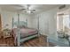 Bedroom with four-poster bed, hardwood floors, ceiling fan, and ensuite access at 1637 W University Dr, Mesa, AZ 85201