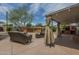 Relaxing patio features wicker furniture, a hot tub, a brick BBQ, and a shaded awning for comfortable outdoor living at 1637 W University Dr, Mesa, AZ 85201