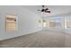 Spacious carpeted bedroom with fan and multiple windows at 1669 E Santa Fiore St, San Tan Valley, AZ 85140