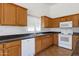 Bright kitchen with wooden cabinets, a stainless steel sink, and white appliances at 1669 E Santa Fiore St, San Tan Valley, AZ 85140