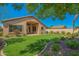 Lush backyard with green grass, landscaping, and covered patio at 17617 W Corrine Dr, Surprise, AZ 85388