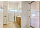 Bathroom with a tile floor, glass shower, single sink vanity, and outdoor access at 17617 W Corrine Dr, Surprise, AZ 85388