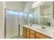 Bathroom featuring a double vanity sink, framed mirror, and glass enclosed shower at 17617 W Corrine Dr, Surprise, AZ 85388