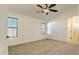 Spacious bedroom with large windows, ceiling fan, and adjoining bathroom at 17617 W Corrine Dr, Surprise, AZ 85388