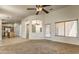 Open-concept living space featuring neutral colors, carpeted floor, and access to the kitchen at 17617 W Corrine Dr, Surprise, AZ 85388