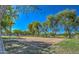Sandy community volleyball court surrounded by mature trees and landscaping at 17617 W Corrine Dr, Surprise, AZ 85388