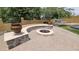 Beautiful outdoor space featuring a stone fire pit with built-in seating, surrounded by lush greenery at 1766 N Channing --, Mesa, AZ 85207