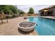 A serene backyard pool with a rock water feature and outdoor lounge area, perfect for relaxation at 1766 N Channing --, Mesa, AZ 85207