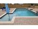 Sparkling blue pool with a Baja shelf and surrounding brick patio, inviting relaxation and entertainment at 1766 N Channing --, Mesa, AZ 85207
