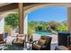 Charming outdoor patio seating area with a view of the pool and lush landscaping at 19947 N 94Th Way, Scottsdale, AZ 85255