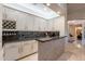 Elegant bar area featuring marble countertops, custom cabinetry, and open access to other rooms at 19947 N 94Th Way, Scottsdale, AZ 85255