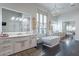 Elegant bathroom featuring a soaking tub, double vanity, and decorative lighting at 19947 N 94Th Way, Scottsdale, AZ 85255