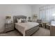 Elegant bedroom with a decorative silver frame bed, neutral tones, and natural light from a large window at 19947 N 94Th Way, Scottsdale, AZ 85255