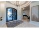 Grand foyer with a chandelier, decorative archway, travertine floors, and a large black-framed glass door at 19947 N 94Th Way, Scottsdale, AZ 85255