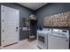 Laundry room featuring gray walls, a door, washer, dryer, and a mirror at 19947 N 94Th Way, Scottsdale, AZ 85255