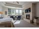 Spacious main bedroom with a fireplace, sitting area and large windows at 19947 N 94Th Way, Scottsdale, AZ 85255