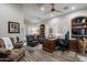 Home office featuring a desk, leather chairs, and built-in shelving at 19947 N 94Th Way, Scottsdale, AZ 85255