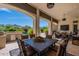 Outdoor covered patio dining with a view of the backyard pool and distant mountains at 19947 N 94Th Way, Scottsdale, AZ 85255