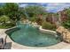 A serene backyard with a swimming pool surrounded by mature landscaping and colorful bougainvillea for a tropical feel at 19947 N 94Th Way, Scottsdale, AZ 85255