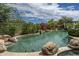 A private backyard featuring a sparkling pool, lush desert landscaping, and a covered patio area at 19947 N 94Th Way, Scottsdale, AZ 85255
