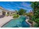 A beautiful backyard oasis with a sparkling pool, lush landscaping, and a covered patio for outdoor living at 19947 N 94Th Way, Scottsdale, AZ 85255