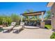 Relaxing pool patio featuring lounge chairs and covered seating area with green backyard at 19947 N 94Th Way, Scottsdale, AZ 85255