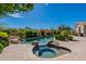 A luxurious pool and spa surrounded by lush landscaping and rock features make for a serene backyard oasis at 19947 N 94Th Way, Scottsdale, AZ 85255