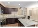 Modern kitchen featuring granite countertops, stainless steel appliances, and dark wood cabinetry at 240 W Juniper Ave # 1211, Gilbert, AZ 85233