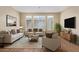 Bright, staged living room with neutral tones, comfortable seating, and ample natural light at 240 W Juniper Ave # 1211, Gilbert, AZ 85233