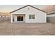 Home exterior featuring a covered patio, a freshly graded yard, and privacy walls at 24066 W Cocopah St, Buckeye, AZ 85326