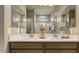 Contemporary bathroom with dual sinks, a large mirror, and modern fixtures, exuding elegance and functionality at 24066 W Cocopah St, Buckeye, AZ 85326