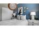 Stylish bedroom with blue walls, unique light fixture, and a comfortable bed with pillows at 24066 W Cocopah St, Buckeye, AZ 85326