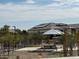 Shaded community seating area featuring multiple benches and an umbrella-like structure with landscaping at 24066 W Cocopah St, Buckeye, AZ 85326