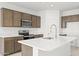 Bright kitchen with an island, modern stainless-steel appliances and plenty of cabinet space at 24066 W Cocopah St, Buckeye, AZ 85326