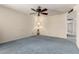 Light-filled bedroom with blue carpet, ceiling fan, and a soft, homey ambiance perfect for relaxation at 2442 N 22Nd Ave, Phoenix, AZ 85009