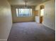 Spacious carpeted living room with large windows offering natural light into the home at 2530 W Berridge Ln # E111, Phoenix, AZ 85017