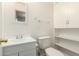 Well-lit bathroom featuring a white vanity, toilet, mirror and built-in shelving at 2802 W Butler Dr, Phoenix, AZ 85051