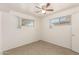 Well-lit bedroom featuring tile flooring, ceiling fan, and two windows at 2802 W Butler Dr, Phoenix, AZ 85051